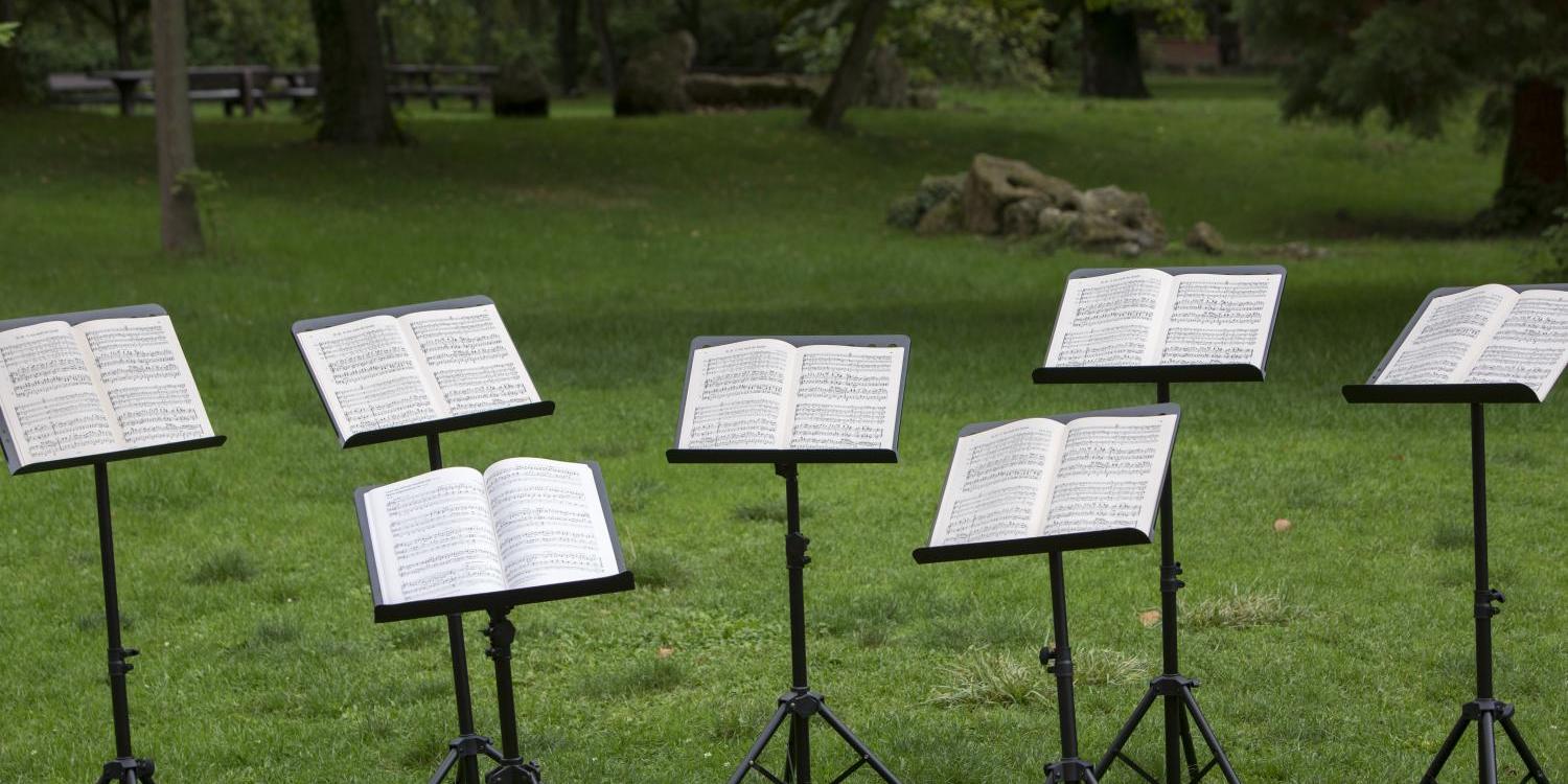 Mehrere Notenständer stehen im Park auf einer Wiese (c) Bild: Bistum Mainz In: Pfarrbriefservice.de Mehrere Notenständer stehen im Park auf einer Wiese